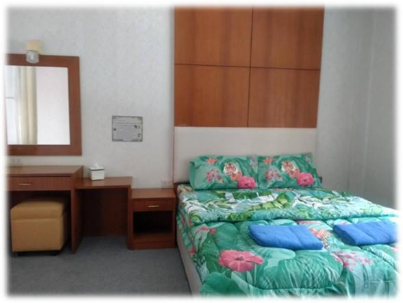 1 dormitorio con cama, escritorio y espejo en ศูนย์ฝึกอบรมสวนสัตว์เปิดเขาเขียว JJJ, 