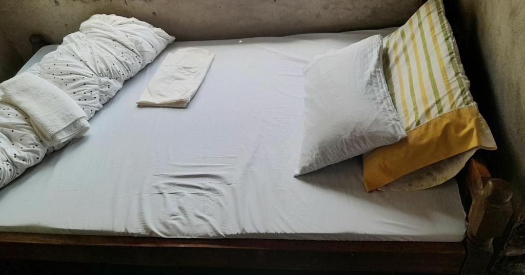 a bed with white sheets and pillows on it at ArushaLand homestay in Arusha