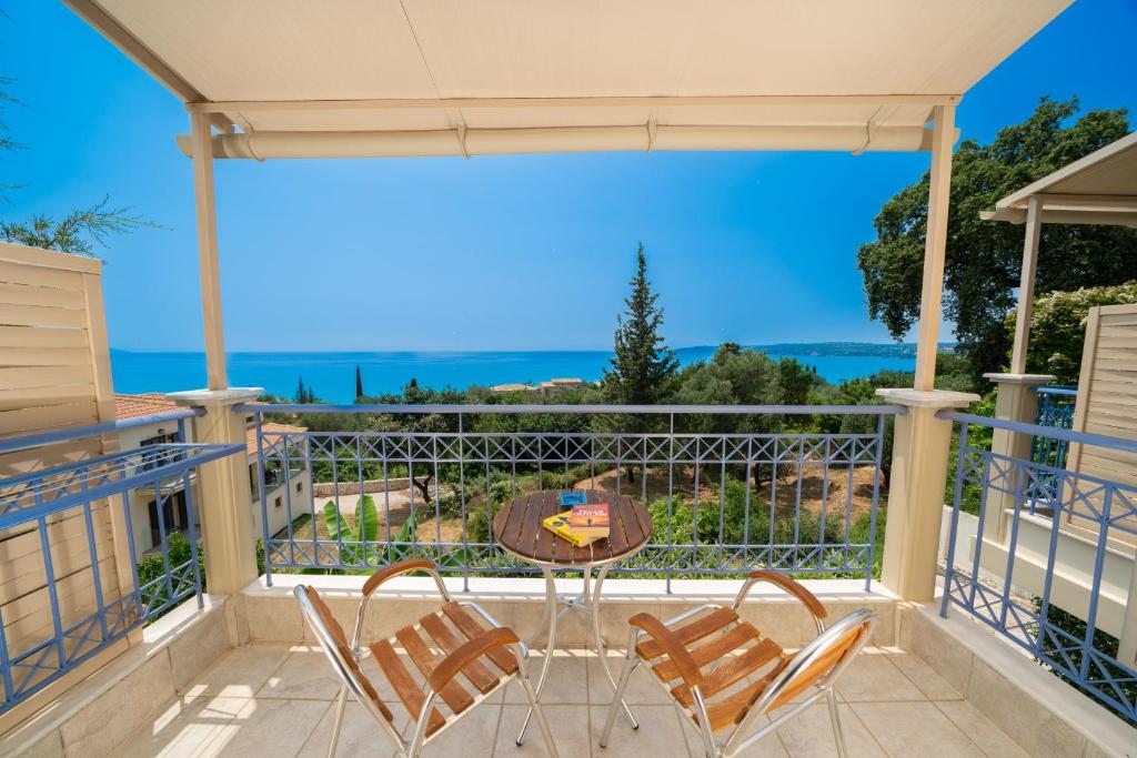 eine Terrasse mit Stühlen und einem Tisch auf dem Balkon in der Unterkunft Agnanti Studios in Lourdata