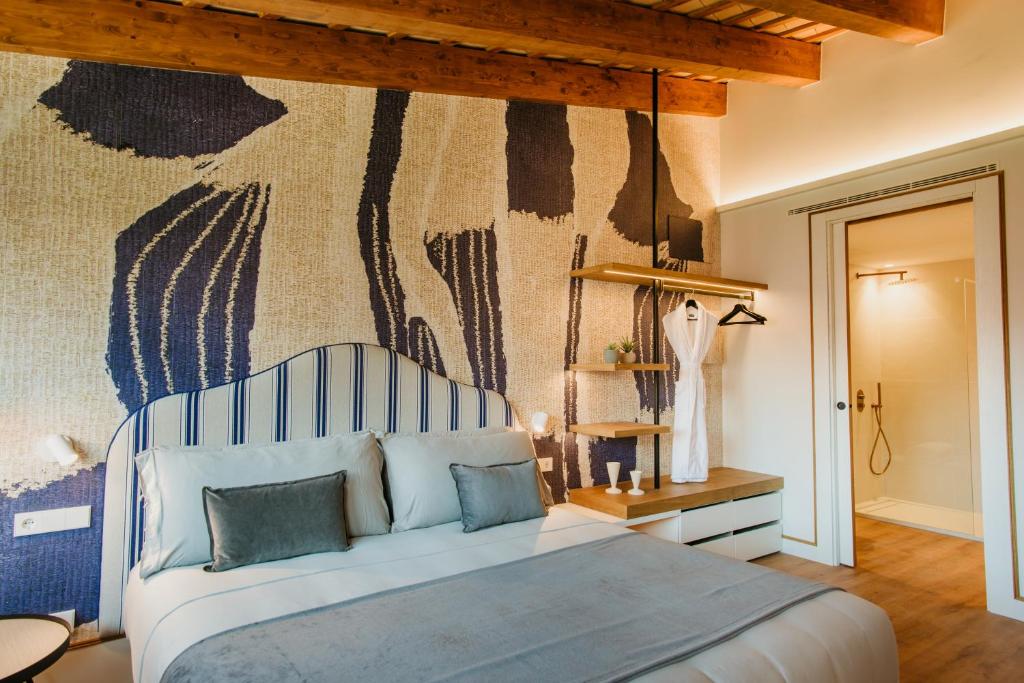 a bedroom with a bed and a wall with a mural at Casa Indiana Hotel Boutique in Blanes