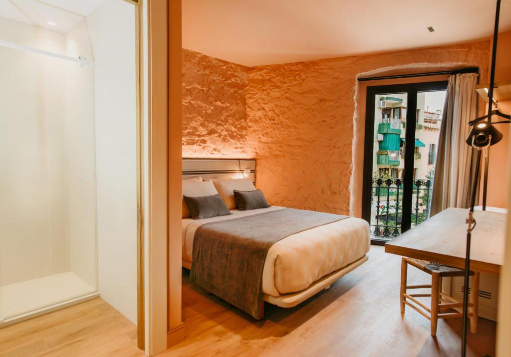 a bedroom with a bed and a table in a room at Casa Indiana Hotel Boutique in Blanes