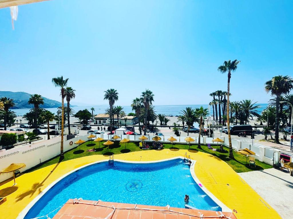 a view of a pool at a resort with palm trees at Velilla Park 2 Playa in Almuñécar