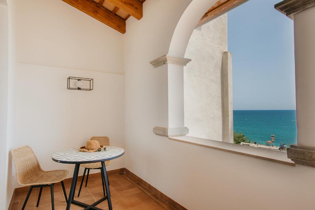 a table and two chairs in a room with a window at Casa Indiana Hotel Boutique in Blanes