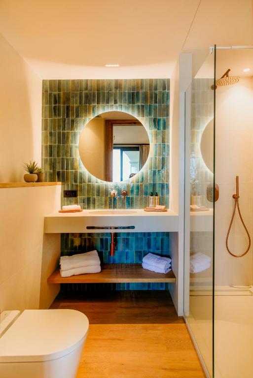 a bathroom with a toilet and a mirror at Casa Indiana Hotel Boutique in Blanes