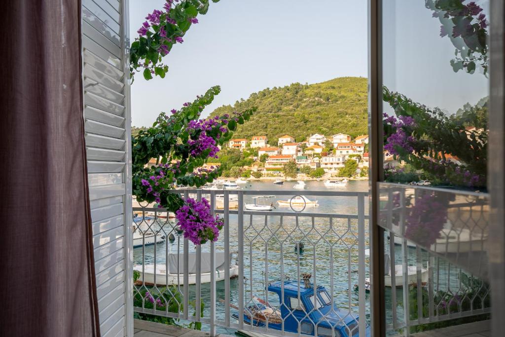 una vista dal balcone di un resort con fiori viola di Bugenvilija apartment a Brna