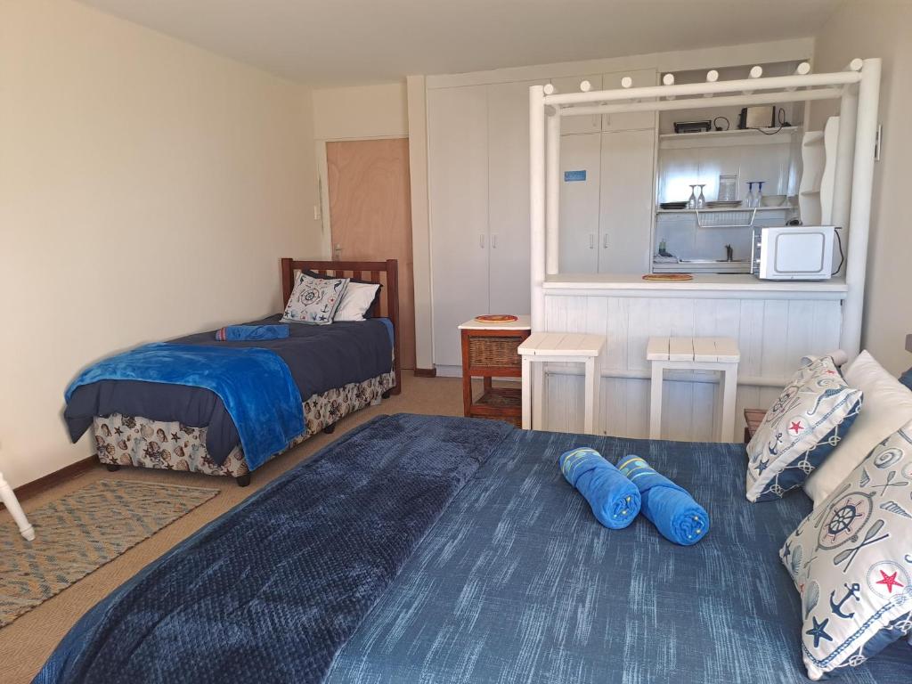 Cet appartement comprend une chambre avec deux lits et un salon. dans l'établissement Ryans Surf Cabin, à Jeffreys Bay