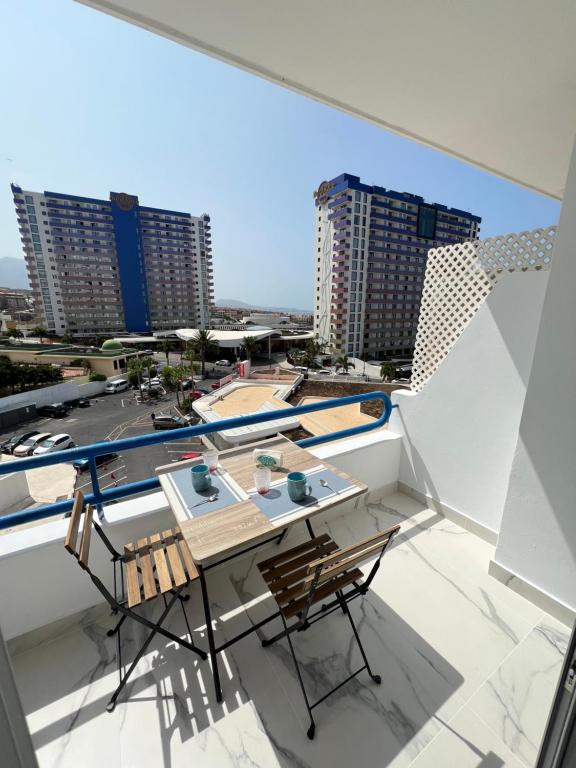 een tafel en stoelen op een balkon met gebouwen bij SWEET PARADISE in Playa Paraiso