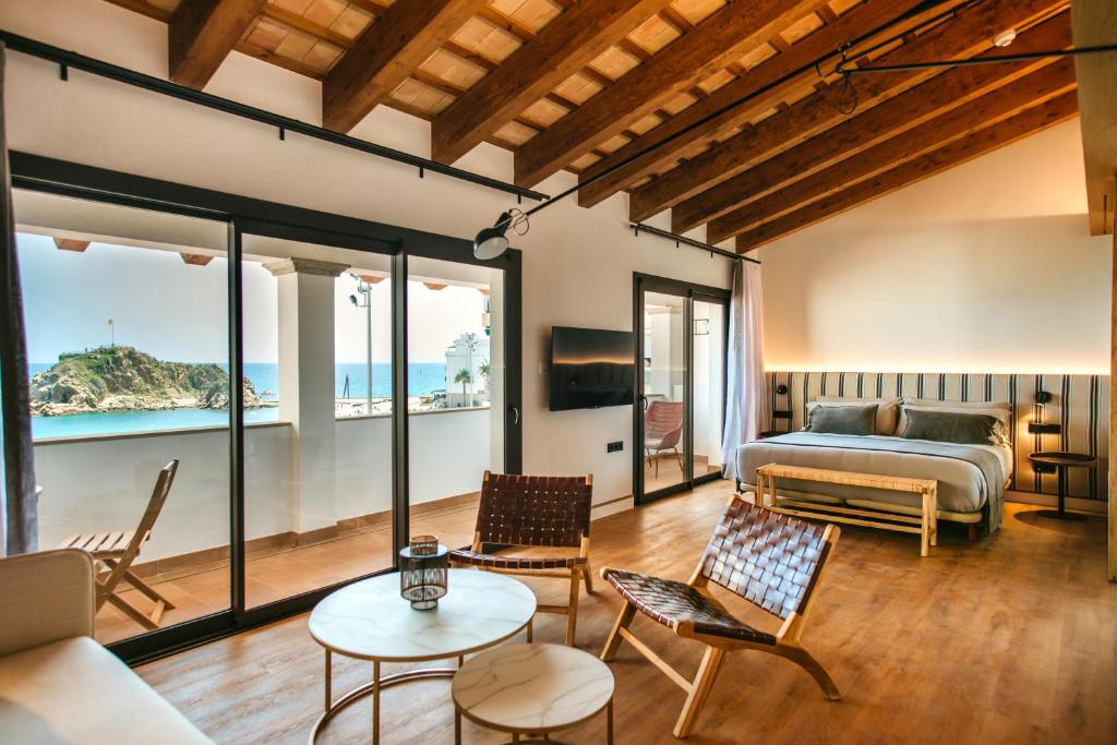 a bedroom with a bed and a view of the ocean at Casa Indiana Hotel Boutique in Blanes