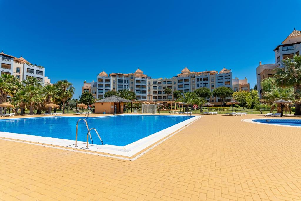 ein Pool in einem Resort mit Gebäuden im Hintergrund in der Unterkunft Las Marismas by Ĥ in Isla Canela