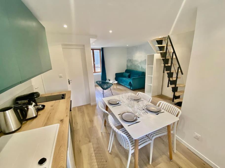 Il comprend une cuisine et un salon avec une table et un escalier. dans l'établissement Le Primevère, à Rouen