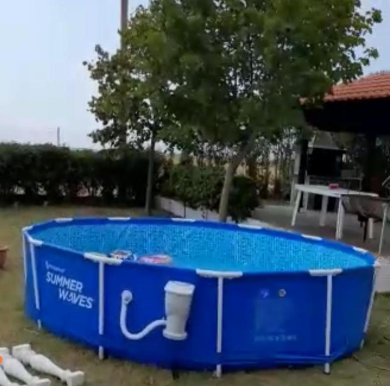 a large blue swimming pool in a yard at ΕΝΟΙΚΙΑΖΟΜΕΝΟ ΔΩΜΑΤΙΟ ΜΕ ΘΕΑ ΣΤΗΝ ΕΞΟΧΗ in Rodhókipos