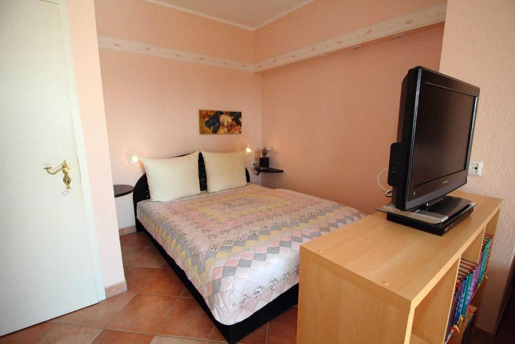 a bedroom with a bed and a television on a desk at Ferienwohnung Gaebel in Sassnitz