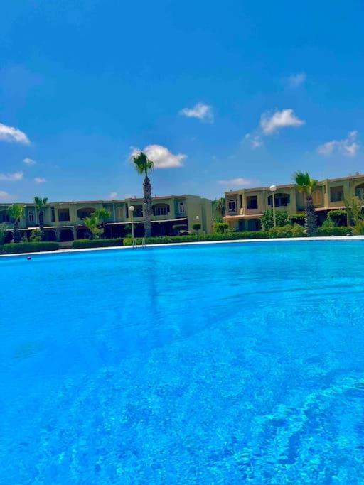 Bazén v ubytování 50% Off. 2BR , 2BR Ground floor with pool view, private beach access, security 24/7 شاليه ٢ غرفه ، ٢ حمام ف الدور الارضي قدام جنينه و حمام السباحه مباشره ، شاطيء خاص بالقرية و أمن ٢٤ ساعه و مسجد خاص nebo v jeho okolí