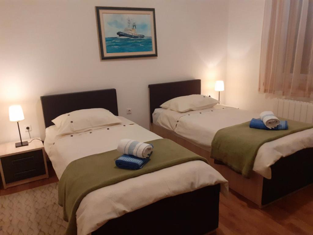 1 dormitorio con 2 camas y toallas. en Apartman Dani en Dražice