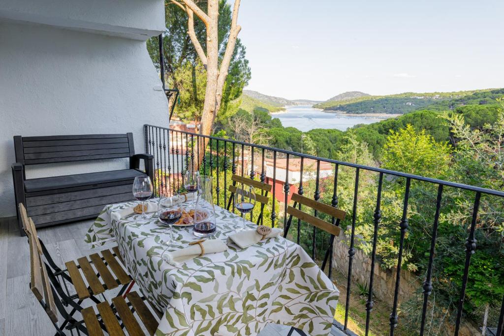 a table on a balcony with a view of the water at Casa Rural la Goleta II in San Martín de Valdeiglesias