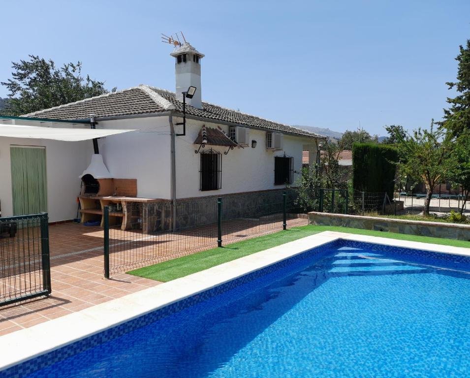 a swimming pool in front of a house at Casa Rural La Maestra in Ronda