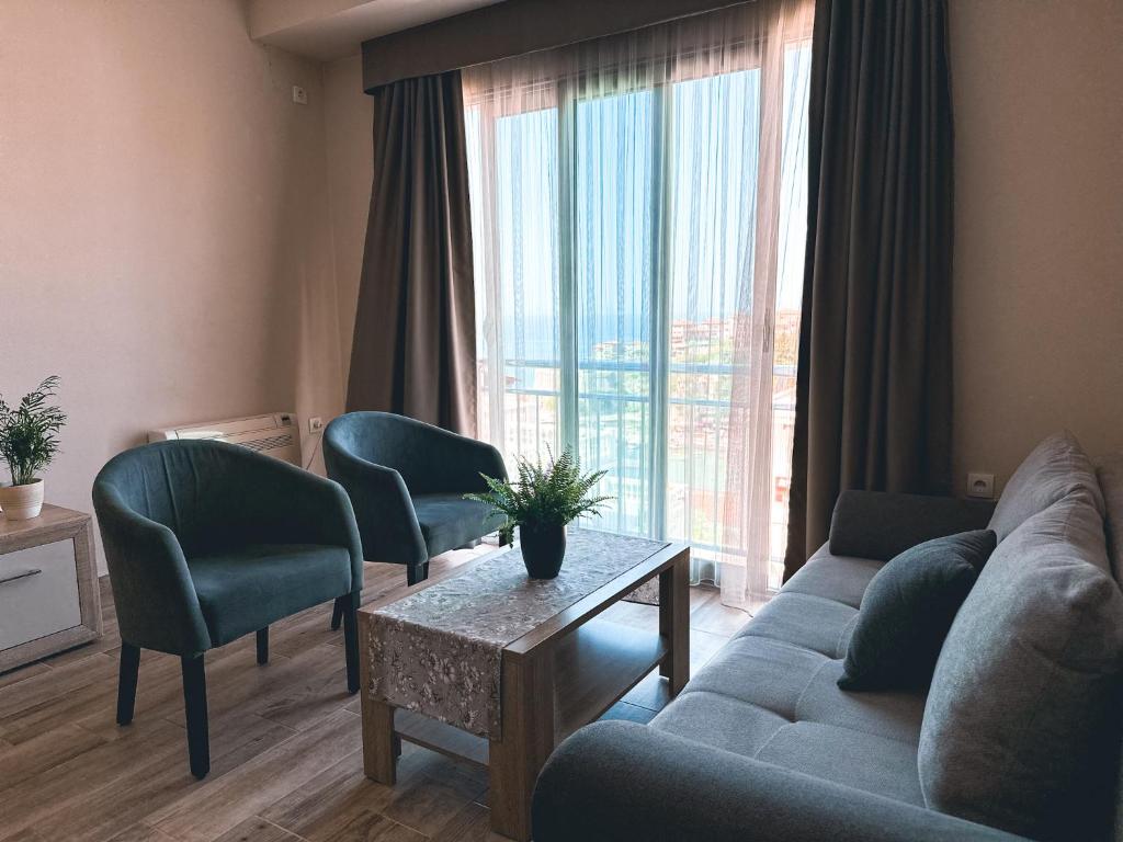 een woonkamer met een bank en stoelen en een groot raam bij Abazovic Apartments in Ulcinj