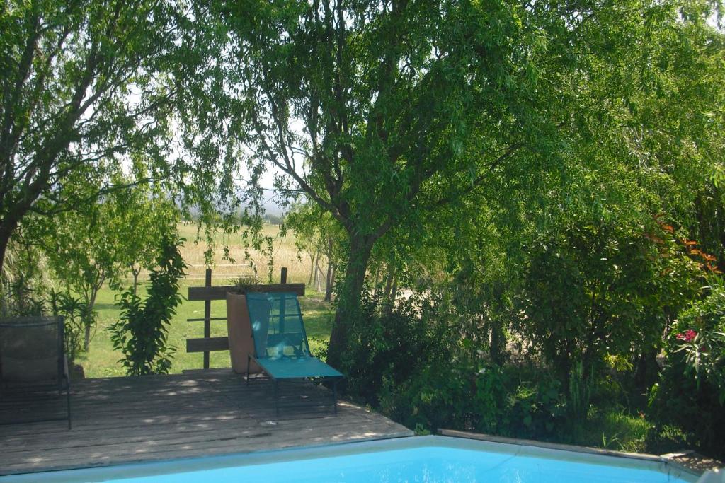 une chaise bleue assise sur une terrasse à côté d'un arbre dans l'établissement Le Luberon Lou Mas Li Pitchoun, à Gordes