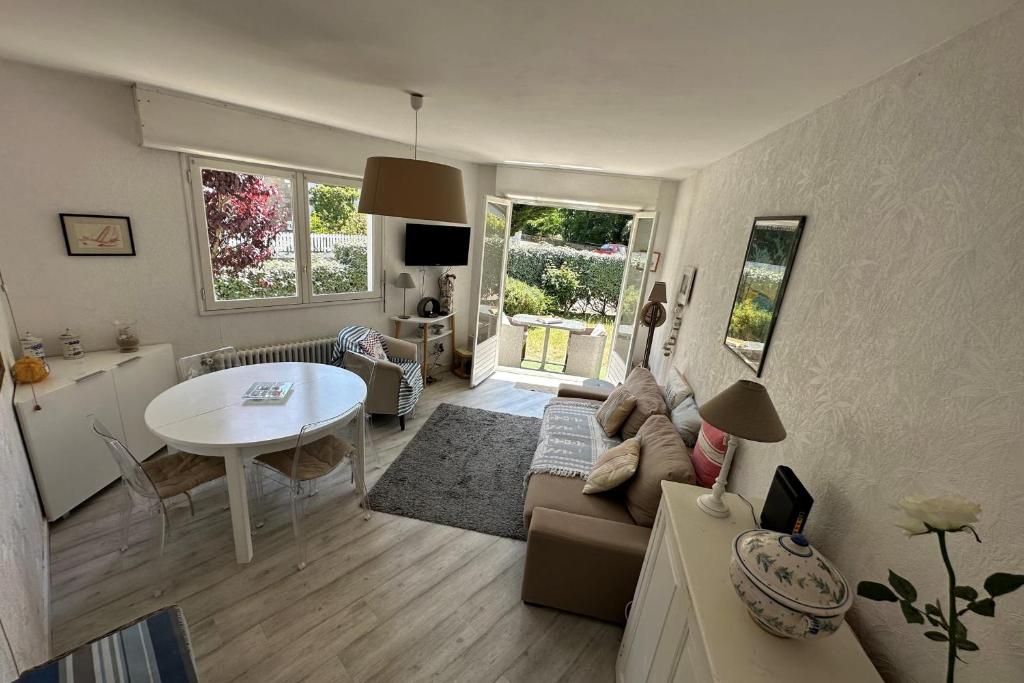 a living room with a couch and a table at Bright cocoon with garden in the heart of La Baule in La Baule