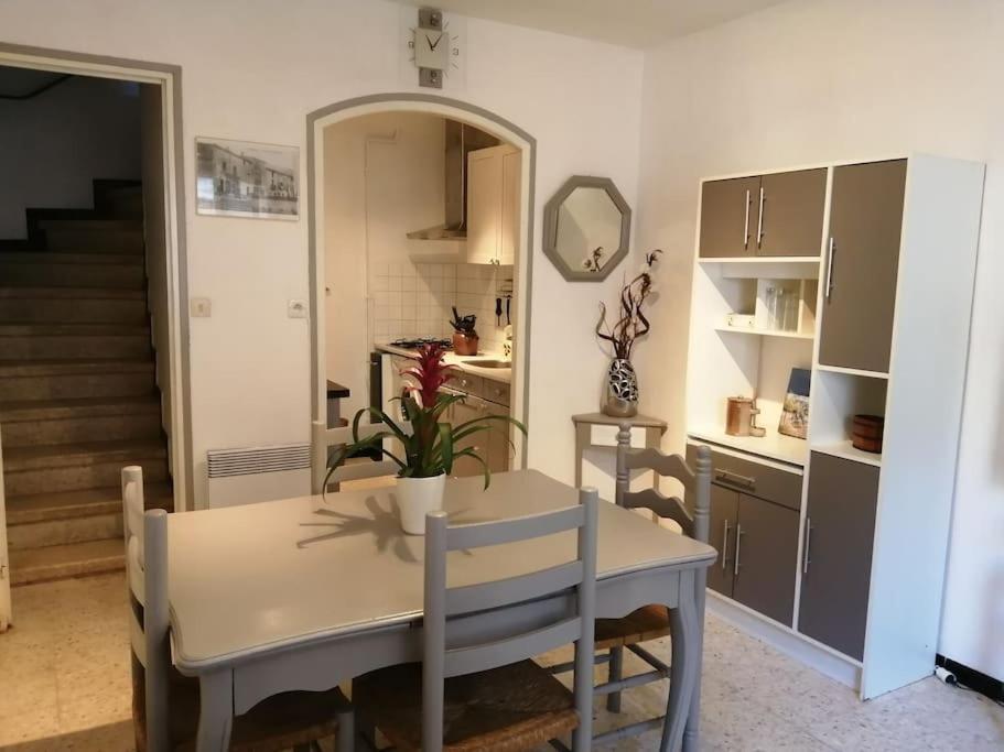uma cozinha e sala de jantar com mesa e cadeiras em L'OUSTAL DE FLO em Florensac