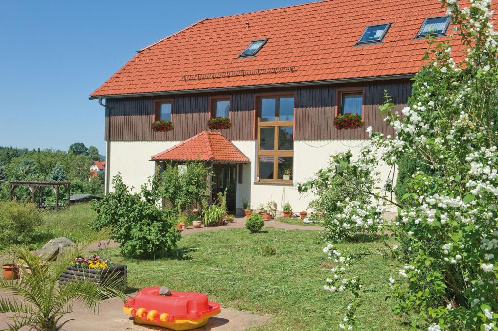 een huis met een rood dak in een tuin bij Ferienpension Gabriele in Kurort Gohrisch