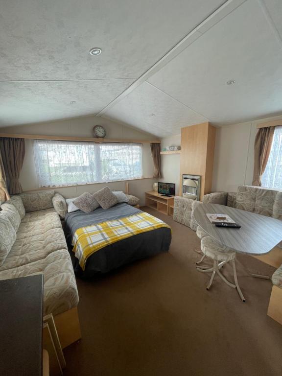 a bedroom with a bed and a table and a couch at The Willerby Vacation in Leysdown-on-Sea