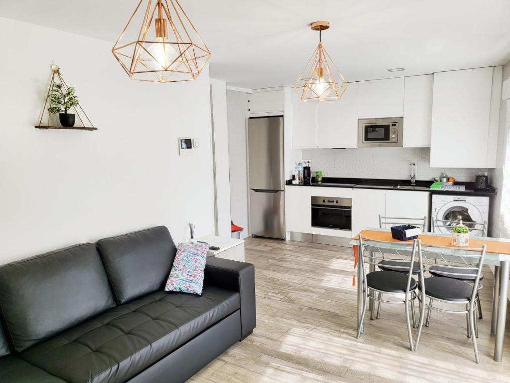 ein Wohnzimmer mit einem Sofa und einem Tisch sowie eine Küche in der Unterkunft Apartamento del Puente in Autol