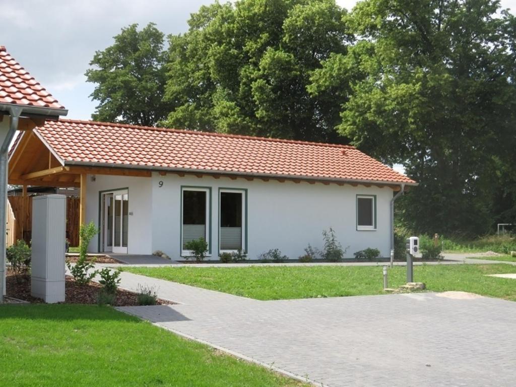 una pequeña casa blanca con techo rojo en Weserberglandalm Haus 3, en Ottenstein