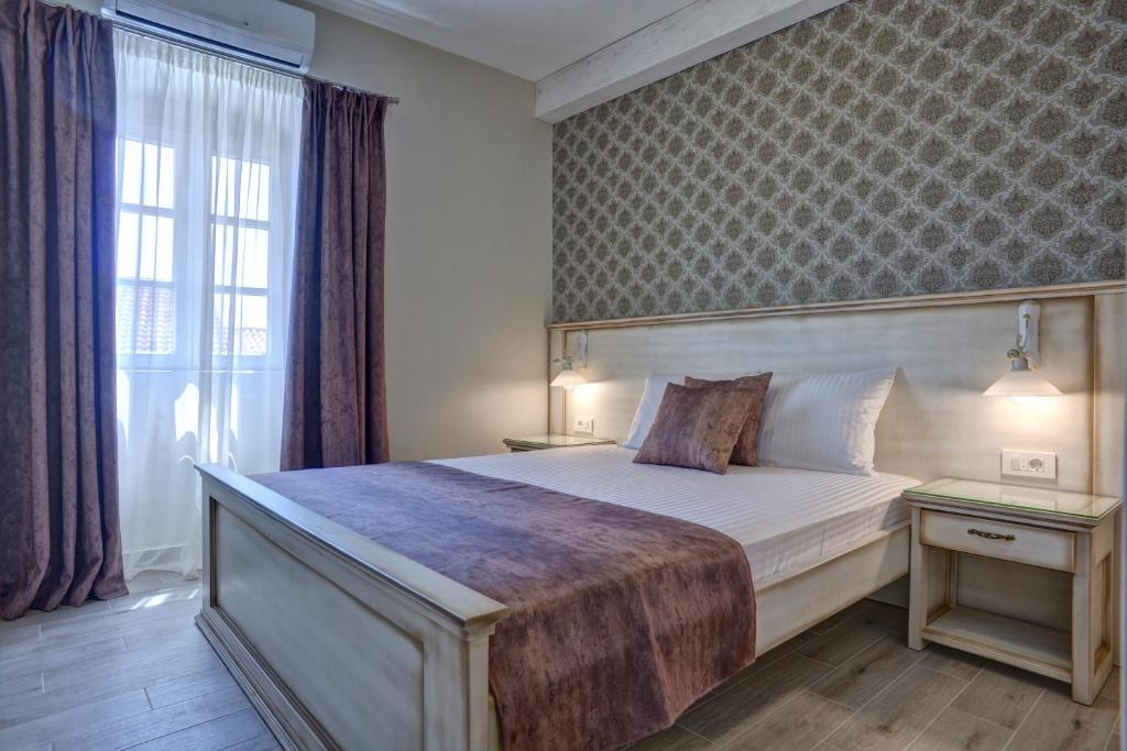um quarto com uma cama grande e uma janela em Piazza Apartments 2 em Petrovac na Moru