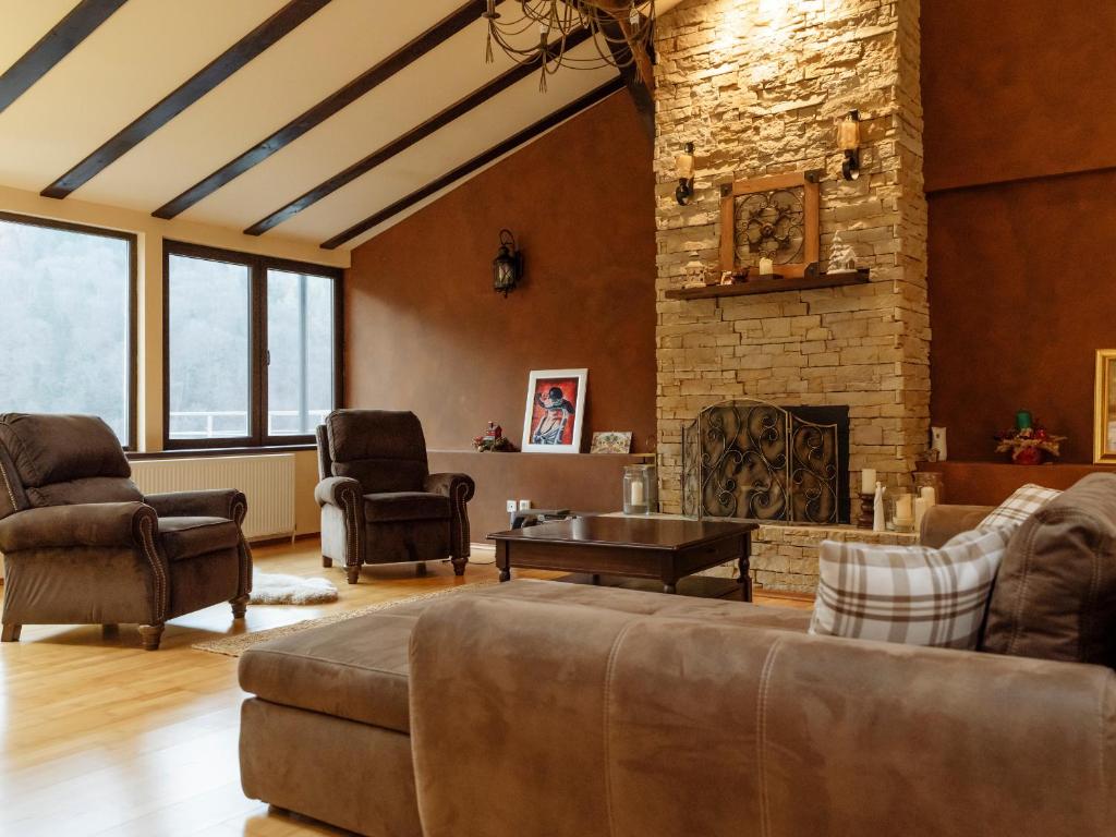 a living room with a couch and a stone fireplace at Constellation Loft Colina Marei with fireplace, xBox & baby crib in Sinaia