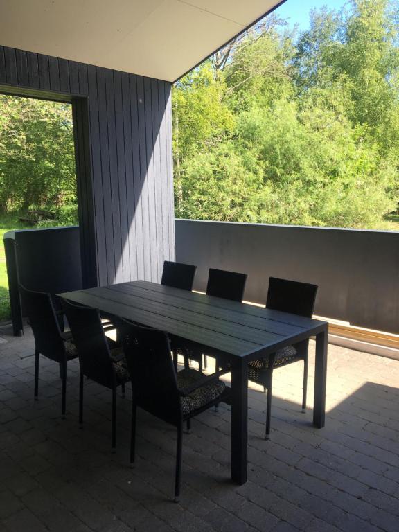 a black table and chairs with a large window at Lerbæk Fiskepark in Frederikshavn