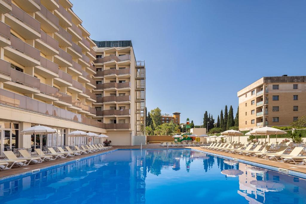 a swimming pool with chairs and a hotel at htop Amatista #htopBliss in Lloret de Mar