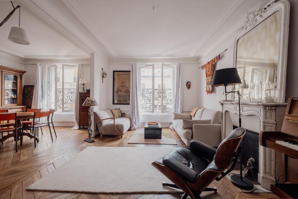 un salon rempli de meubles et d'une cheminée dans l'établissement Veeve - Mid-century Mystique, à Paris