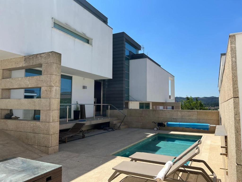 een huis met een zwembad op een patio bij Moradia Lux RR com piscina in Penafiel