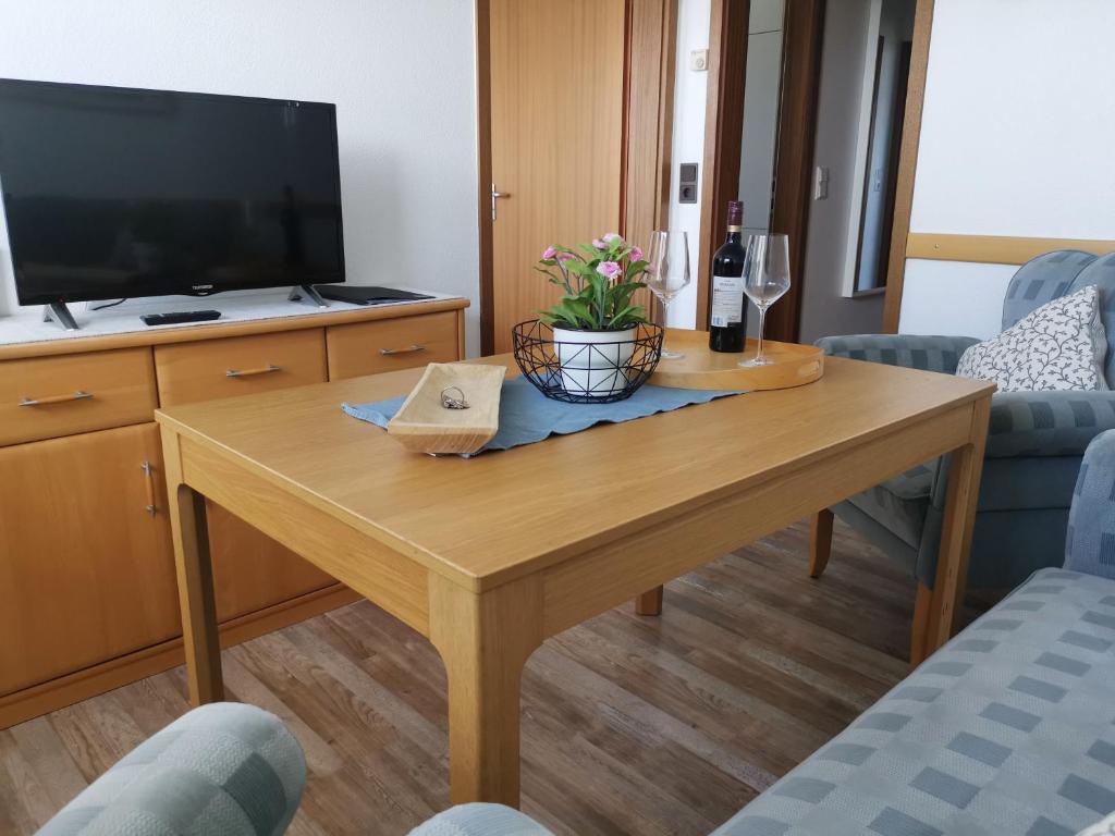 a living room with a wooden table and a tv at Ferienhaus Rosenboom Rosenboom 02 in Norderney