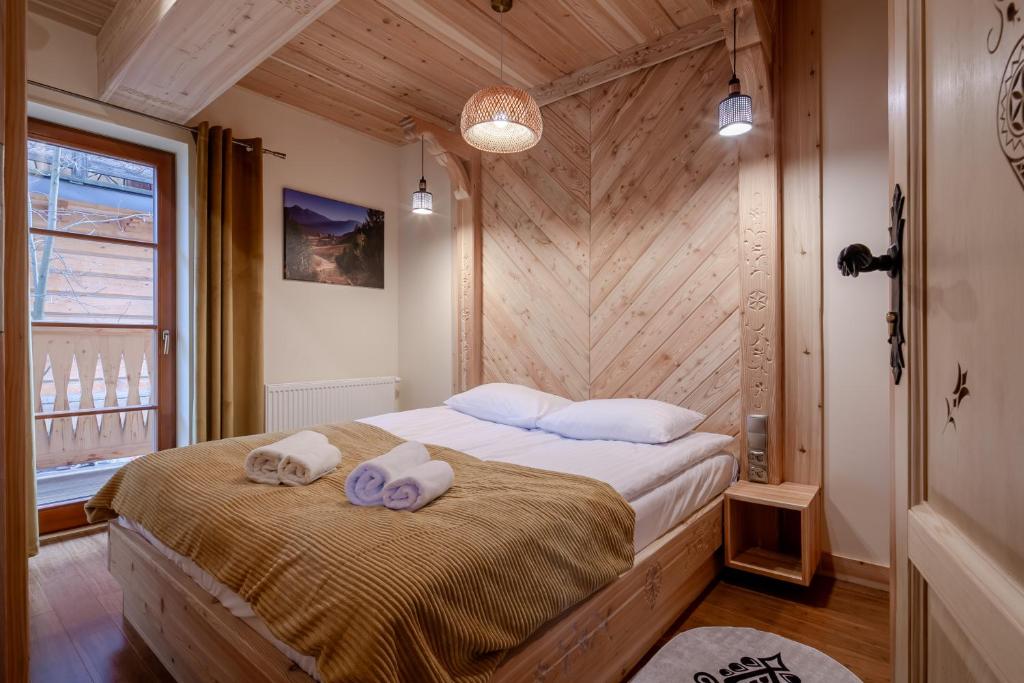 a bedroom with a bed with two towels on it at Górskie Szczyty Apart & SPA Hawrań Sauna Jacuzzi i Parking w cenie in Zakopane