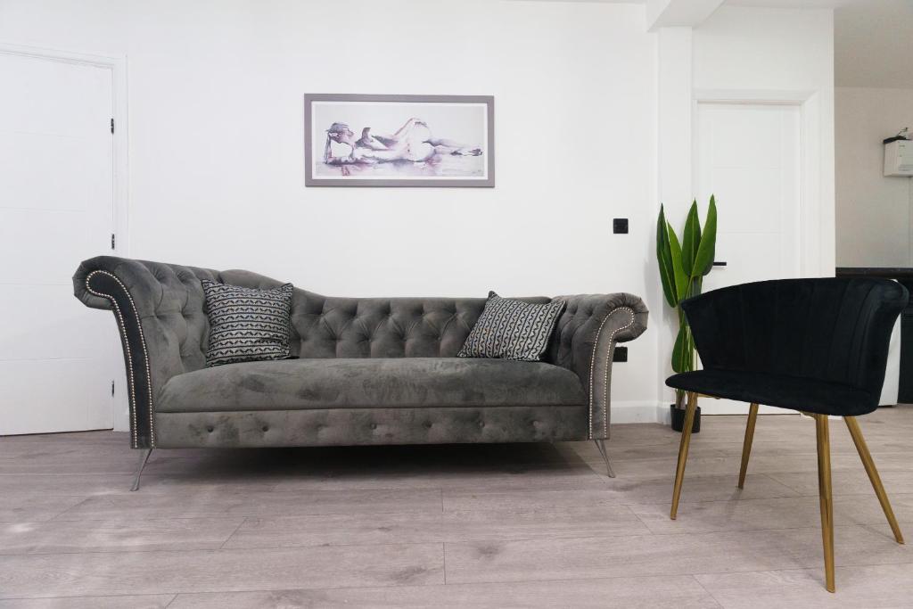 a living room with a couch and a chair at Fewston House in Leeds