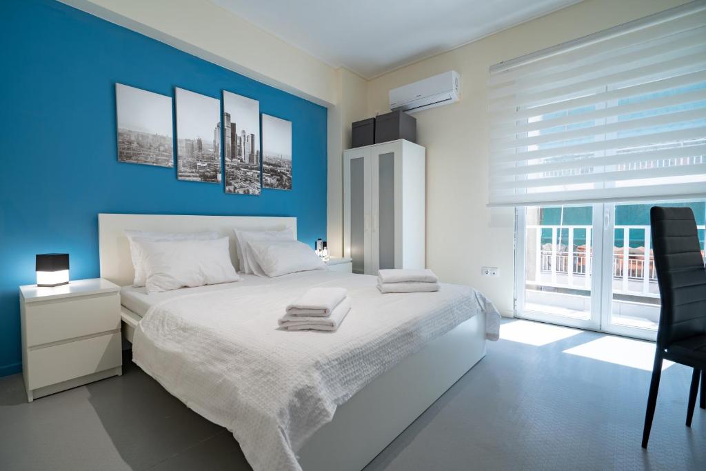 1 dormitorio con 1 cama blanca grande y paredes azules en Awesome, en Atenas