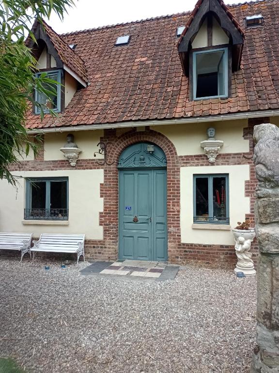 une maison avec une porte verte et un banc dans l'établissement Bergerie Bracquetuit, à Bracquetuit