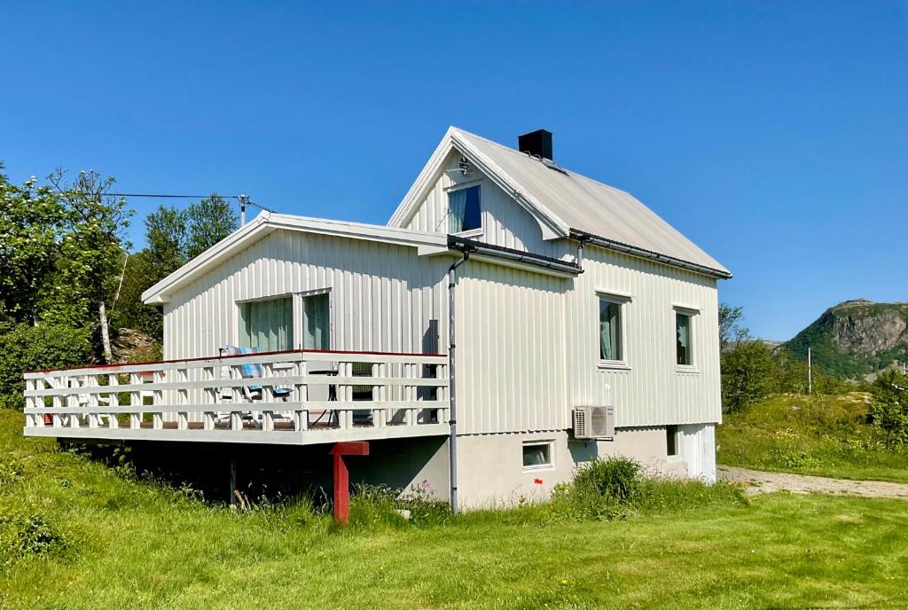 a large white house with a porch on a hill at Fishermans Paradise Lofoten in Leknes