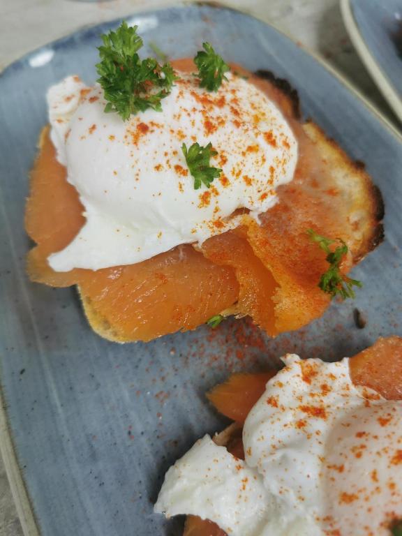 a blue plate with a fried egg on top of bread at Baginbun Lodge in Fethard on Sea