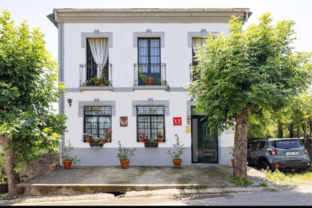 una casa blanca con un coche aparcado delante de ella en Casona de la Ribeira Sacra en Pobra do Brollón