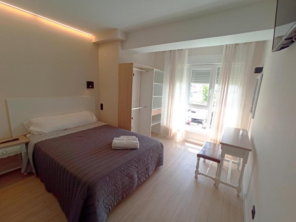 a small bedroom with a bed and a window at Bahia Rooms Cantabria 3000 in Santander