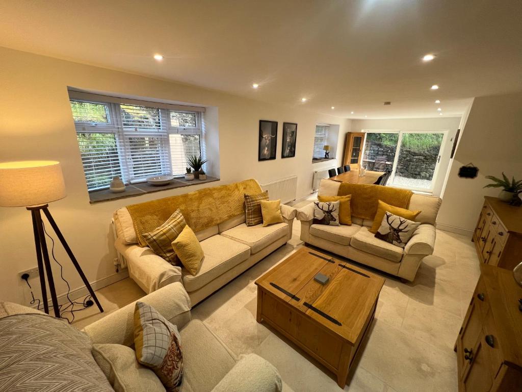 a living room with couches and a coffee table at Stunning Home with STARGAZING ROOM Near Kielder Water in Greenhaugh