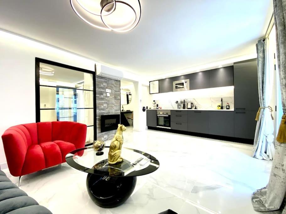 sala de estar con silla roja y mesa de cristal en Gran-Via Luxury Flat 3BD City Center + Terrace + AC, en Madrid