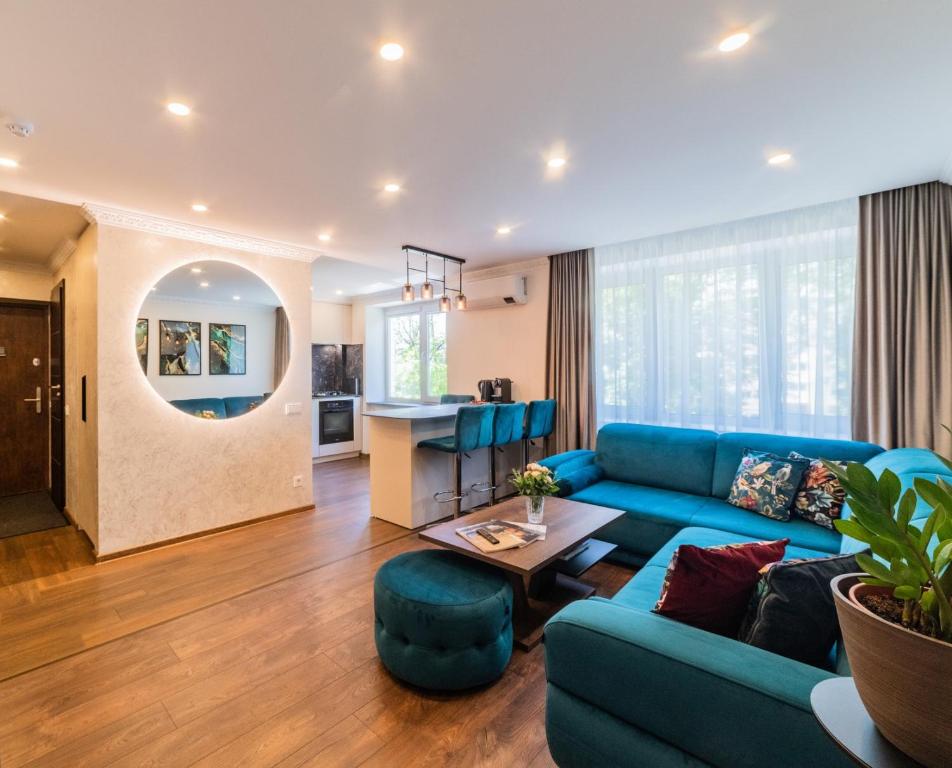 uma sala de estar com um sofá azul e uma mesa em E. D. Elite Apartment em Siauliai