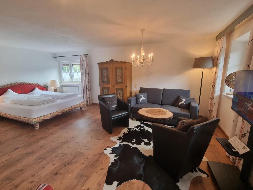 a living room with a bed and a couch at Gästehaus Angela in Garmisch-Partenkirchen