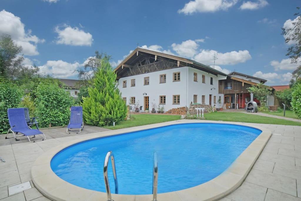 a swimming pool in front of a house at Der Birkenhof-Ried in Pfaffing