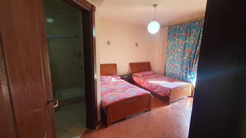 a small room with two beds and a shower at جولف بورتو مارينا in El Alamein