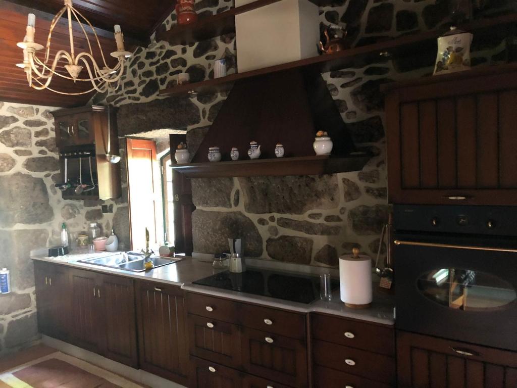 - une cuisine avec un évier et un mur en pierre dans l'établissement QUINTA DONA MANUELA, à Formariz